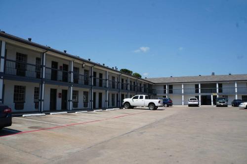 a white truck parked in a parking lot in front of a building at Sherman Inn in Sherman
