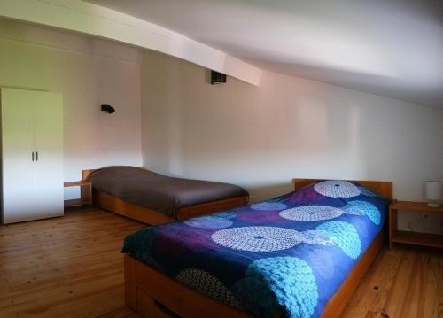 une chambre avec deux lits dans une pièce dans l'établissement Gite La maison de Popey, à Saint-Romain-de-Popey