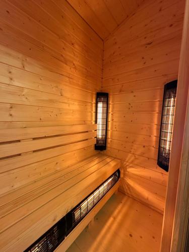 a wooden interior of a sauna with two windows at Domki Lux Gródek nad Dunajcem in Gródek Nad Dunajcem