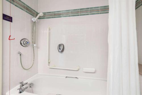 a bathroom with a bath tub with a shower curtain at Days Inn Lockerbie - Annandale Water in Johnstonebridge