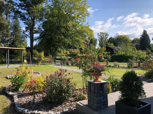 a garden with a vase on a brick pillar at Ferienhaus am Tannenbad in Bergen an der Dumme