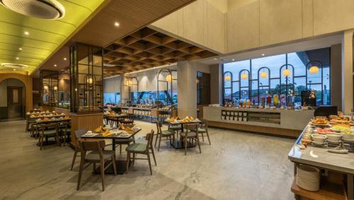 a restaurant with tables and chairs and a cafeteria at Swiss-Belinn Indramayu in Indramayu