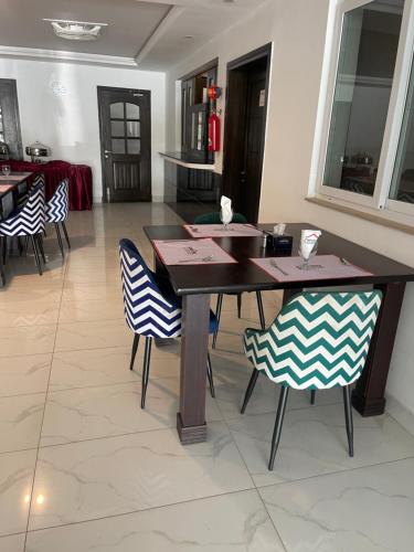 a dining room with a wooden table and chairs at Islamabad Royal in Islamabad