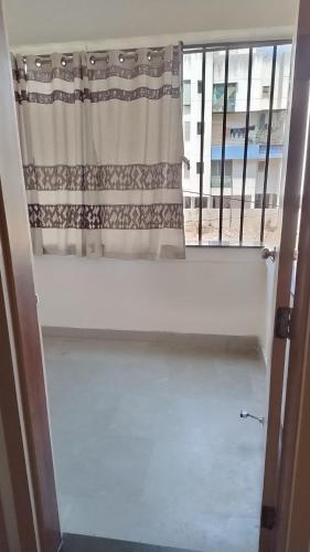 a window with a curtain in a room at DatsunG Studios Near Pune Airport in Pune