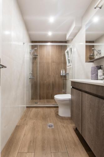 a bathroom with a shower and a toilet and a sink at Houseloft White Tower Icon in Thessaloniki