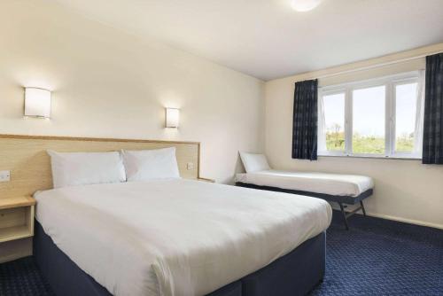 a hotel room with a large bed and a window at Days Inn Sutton Scotney North in Sutton Scotney