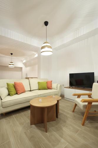 a living room with a couch and a tv at L 25 Apartments in Bitola