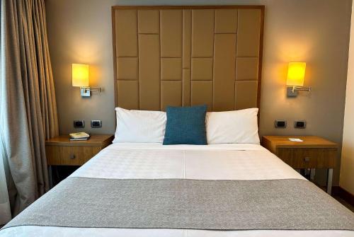 a bedroom with a large bed with two night stands at Wyndham Garden Quito in Quito