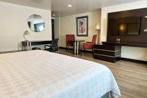 a hotel room with a bed and a flat screen tv at Wyndham Garden Quito in Quito