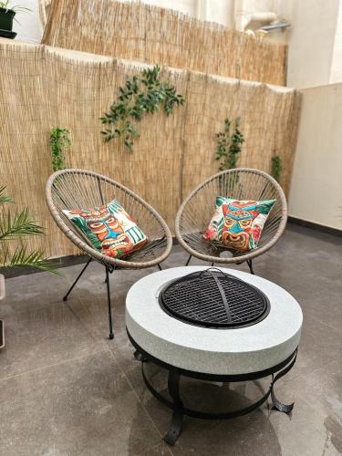 two wicker chairs with a table in a room at Boho Luxe Terrace - Brand New & Terrace in St Julian's