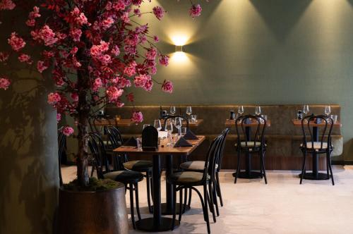 a restaurant with tables and chairs and pink flowers at Hotel Walram in Valkenburg