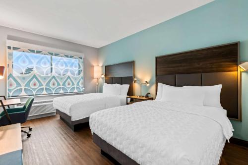 a hotel room with two beds and a window at Tru By Hilton Aloha Beaverton in Beaverton