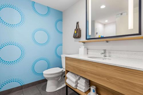 a bathroom with a toilet and a blue wall at Tru By Hilton Aloha Beaverton in Beaverton