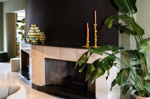 a fireplace in a living room with two candles at Hotel Walram in Valkenburg
