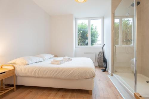 - une chambre blanche avec un lit et une douche dans l'établissement Very nice apartment for 2 people, Le Macon Park free, à Mulhouse