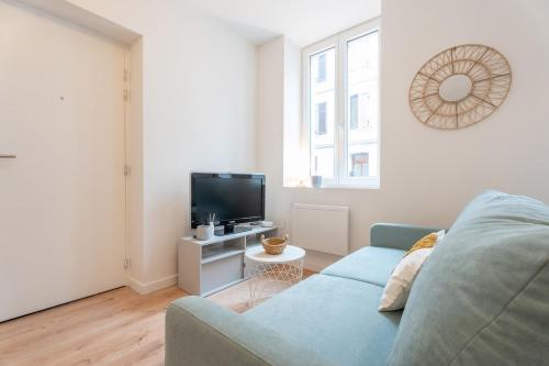 un salon avec un canapé bleu et une télévision dans l'établissement Very nice apartment for 2 people, Le Macon Park free, à Mulhouse