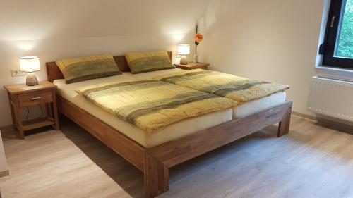 a bedroom with a large bed with two night stands at Spreewaldferienhaus Kupa in Burg