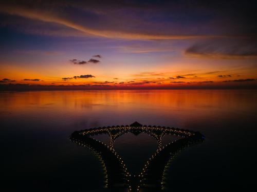 a sunset over the water with the ocean at Cinnamon Velifushi Maldives in Keyodhoo