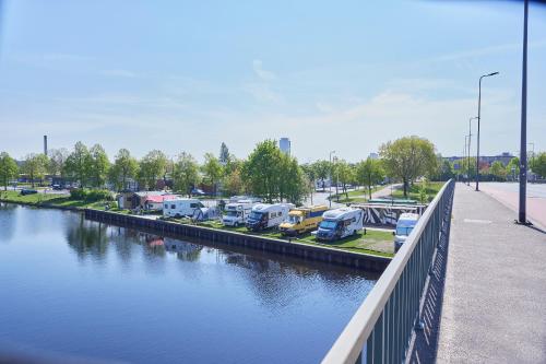 a group of trucks parked in a parking lot next to a river at Tetris Tiny House in Den Bosch