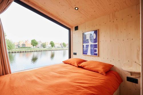 a bed in a small room with a large window at Tetris Tiny House in Den Bosch