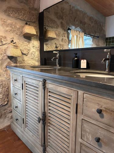 La salle de bains est pourvue d'une coiffeuse avec un lavabo et un miroir. dans l'établissement La Maison de Paul en Aubrac - Lozère, à Fontans