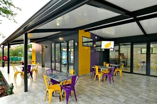 a restaurant with purple chairs and tables on a patio at SleepOver Punda Maria Gate in Punda Maria