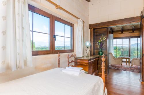 a bedroom with a bed and a large window at Es Rafal Nostro in Felanitx