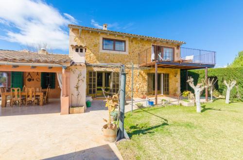 a stone house with a balcony and a patio at Es Rafal Nostro in Felanitx