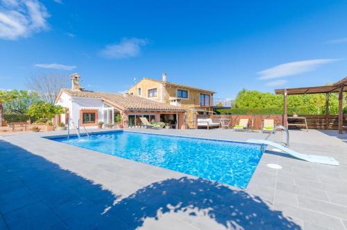 a villa with a swimming pool and a house at Es Rafal Nostro in Felanitx