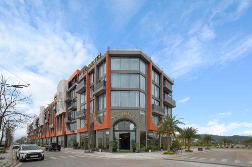 an orange building with a car parked in front of it at Sơn Hotel Vân Đồn in Tài Xá