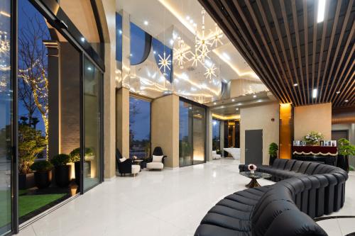 a lobby of a building with a couch and chairs at Sơn Hotel Vân Đồn in Tài Xá