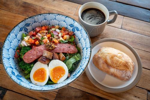 a bowl of food with meat and vegetables and a cup of coffee at LAMP Nojiriko The Sauna by the Lake in Shinano