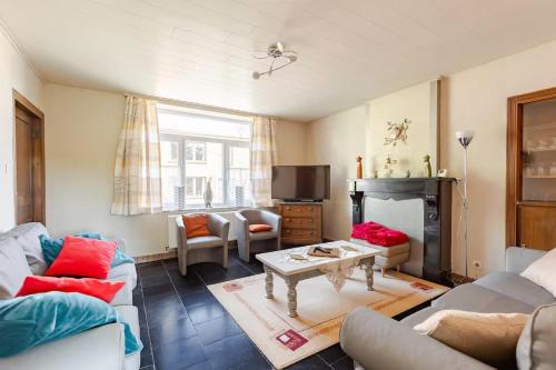a living room with a couch and a fireplace at Agréable Gite Au Fil du Temps in Walcourt