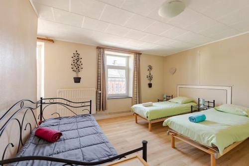 a bedroom with two beds and a couch at Agréable Gite Au Fil du Temps in Walcourt