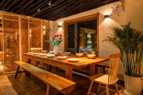 a dining room with a wooden table and chairs at Xianxiuju Garden Courtyard B&B in Fenghuang