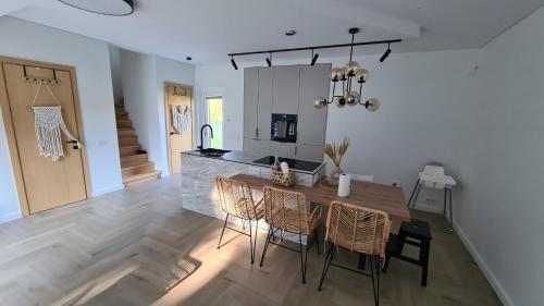 eine Küche und ein Esszimmer mit Tisch und Stühlen in der Unterkunft Vila MurMur Papėje in Pape