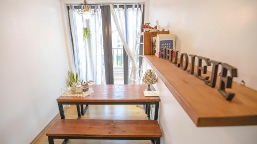 a dining room with a wooden table and a window at Hello jeje Guesthouse in Jeonju