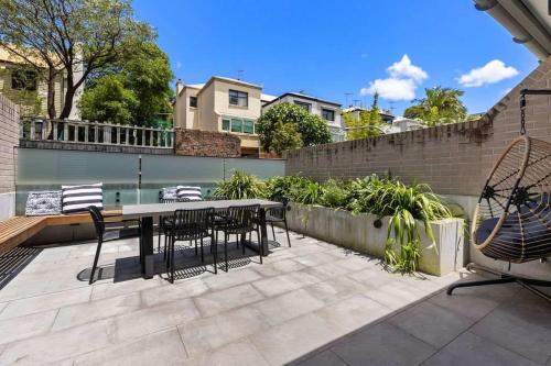 a patio with a table and chairs and a pool at Beautiful Holiday Home w Private Terrace in Sydney