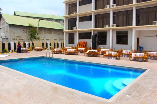 a swimming pool in front of a hotel at Rungwe City Hotel in Dar es Salaam