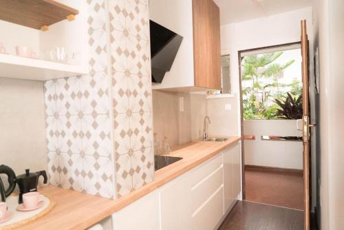 een keuken met witte kasten, een gootsteen en een raam bij Central Charco in Puerto de la Cruz