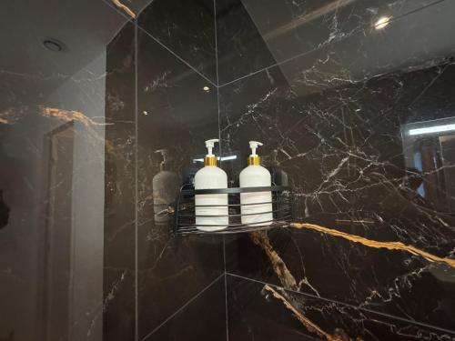 - une salle de bains avec 3 bouteilles de shampoing sur un mur dans l'établissement Beau studio à Nice Centre, à Nice