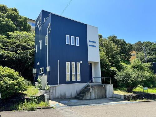 a blue building with a staircase in front of it at 白浜温泉付き貸別荘b-72 in Shirahama