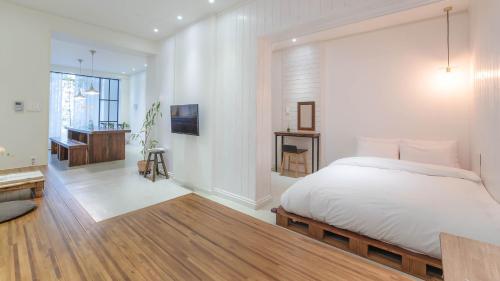 a white bedroom with a bed and a bathroom at Hello jeje Guesthouse in Jeonju