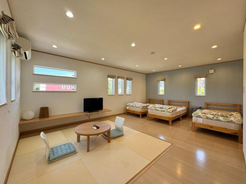 a large room with two beds and a tv at 白浜温泉付き貸別荘b-72 in Shirahama