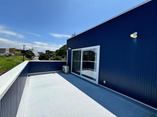 a blue building with a large window on the side of it at 白浜温泉付き貸別荘b-72 in Shirahama