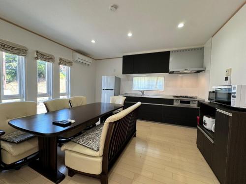 a kitchen and dining room with a table and chairs at 白浜温泉付き貸別荘b-72 in Shirahama