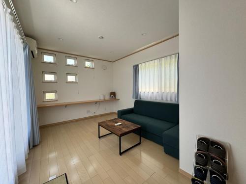 a living room with a green couch and a table at 白浜温泉付き貸別荘b-72 in Shirahama