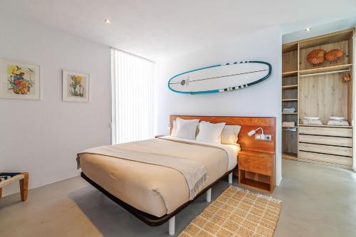 a bedroom with a bed with a surfboard on the wall at Surf House in Sant Josep de Sa Talaia