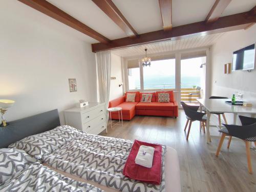a bedroom with a bed and a table and a couch at MOOKI Mountain & Pool Gerlitzen Apartment in Kanzelhöhe