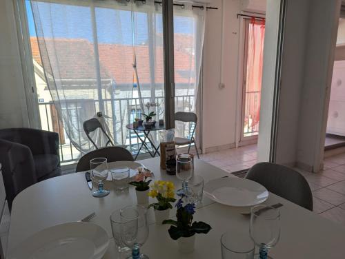 - une table blanche avec des verres et des fleurs dans l'établissement Sol-y-Days Vidourle rive droite, quartier calme 100m des plages et proche centre-ville, au Grau-du-Roi